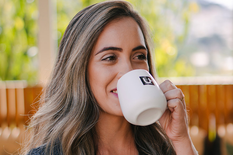Mulher tomando café em caneca personalizada