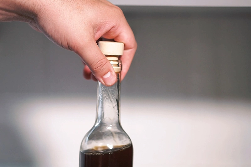 Mãos segurando a garrafa de licor de café