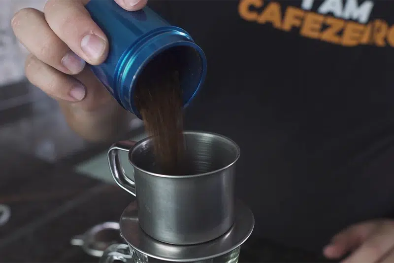 Adicionando água quente no equipamento de filtragem do café