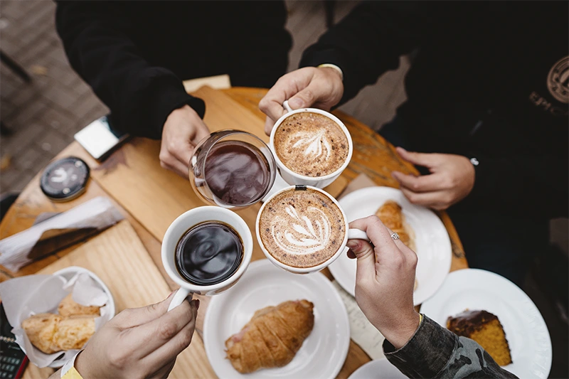 Encontro de amigos brindando com café na cafeteria