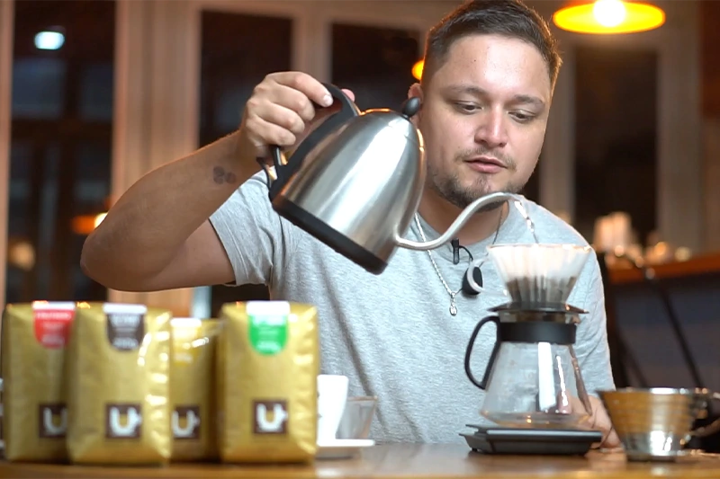 Barista adicionando água para extração do café na Kalita Wave