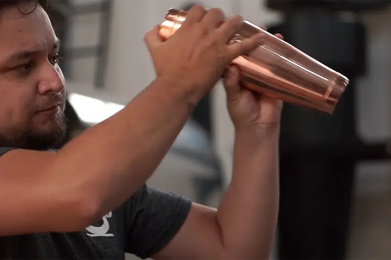 Barista agitando uma coqueteleira de metal