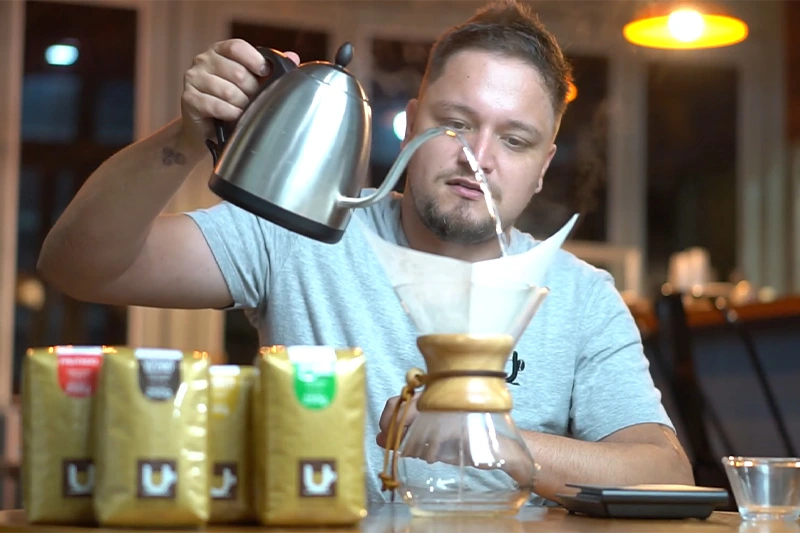 Barista mostrando técnica de molhar o filtro de papel antes do preparo