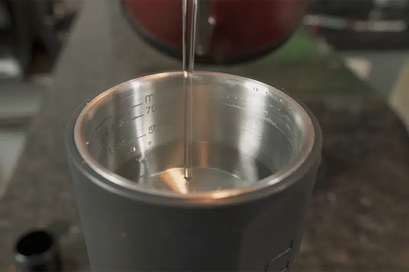 Adicionando água no compartimento da máquina de espresso