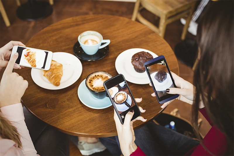 Clientes tirando fotos dos produtos da cafeteria nas redes sociais