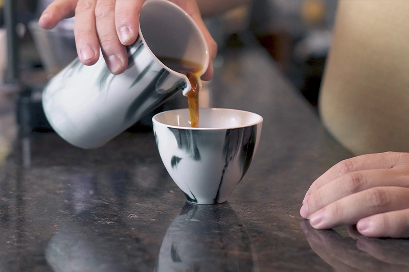 Servindo café especial na xícara de porcelana